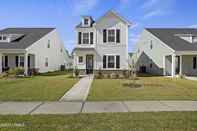 69 Garden Gate Ln, Hardeeville, SC 29927 - traditional-style home with board and batten siding, a front lawn, central air condition unit, and brick siding