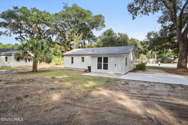 back of property featuring driveway and a patio