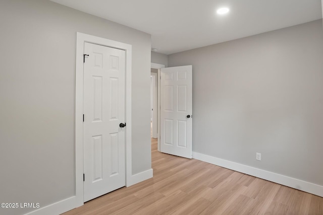 unfurnished bedroom featuring light wood-style flooring and baseboards