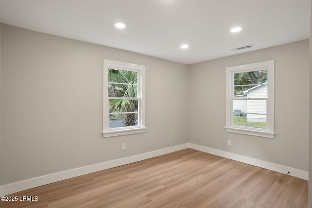 empty room with recessed lighting, visible vents, light wood finished floors, and baseboards
