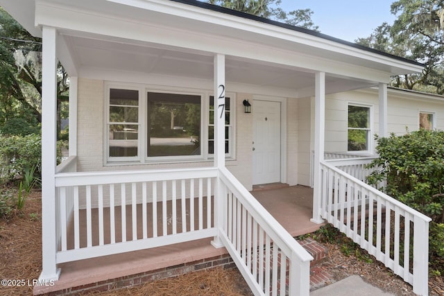 entrance to property with brick siding and covered porch