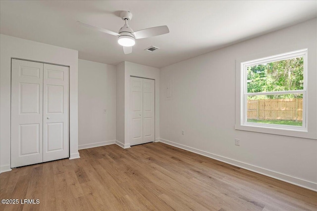 14 Twin Lakes Rd, Beaufort, SC 29902 - unfurnished bedroom featuring baseboards, visible vents, light wood-style floors, a ceiling fan, and two closets