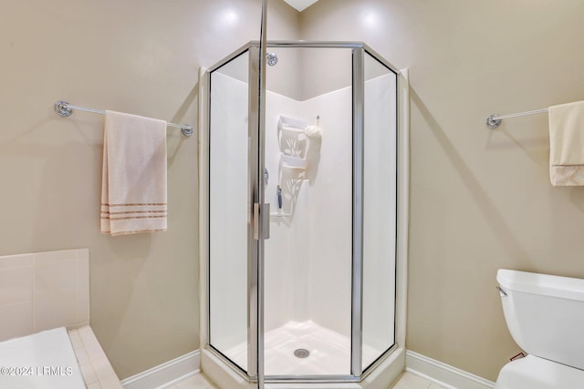 bathroom featuring toilet and a shower with shower door