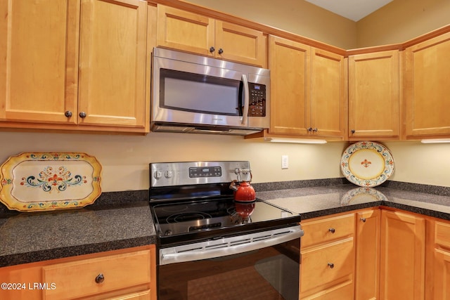 kitchen featuring built in desk and appliances with stainless steel finishes