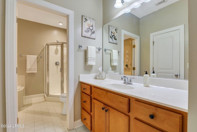 bathroom featuring vanity, toilet, tile patterned flooring, and a shower with door