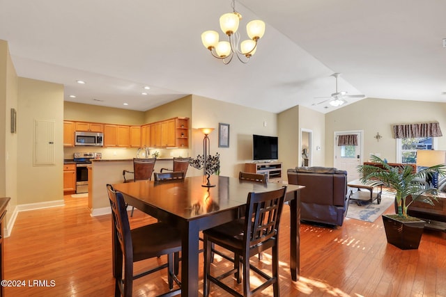 dining space with lofted ceiling, ceiling fan with notable chandelier, and light wood-type flooring