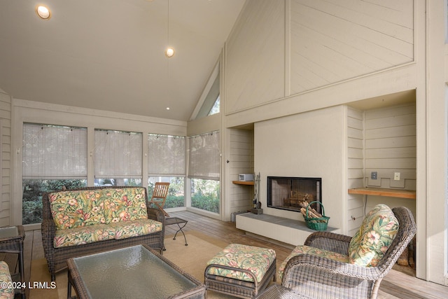 living room featuring hardwood / wood-style flooring, a fireplace, and high vaulted ceiling