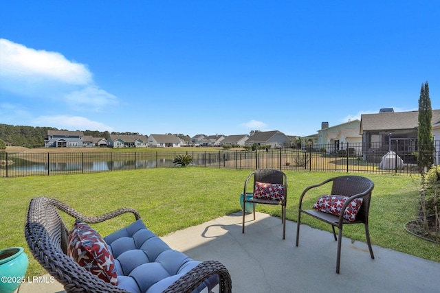 view of patio with a residential view, a water view, and fence