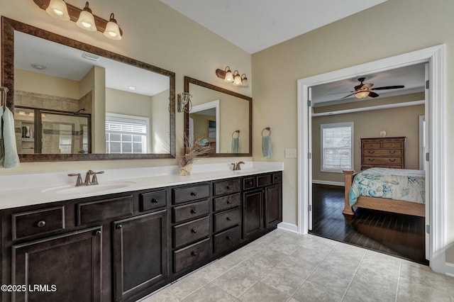 full bathroom featuring tile patterned floors, connected bathroom, a stall shower, and a sink