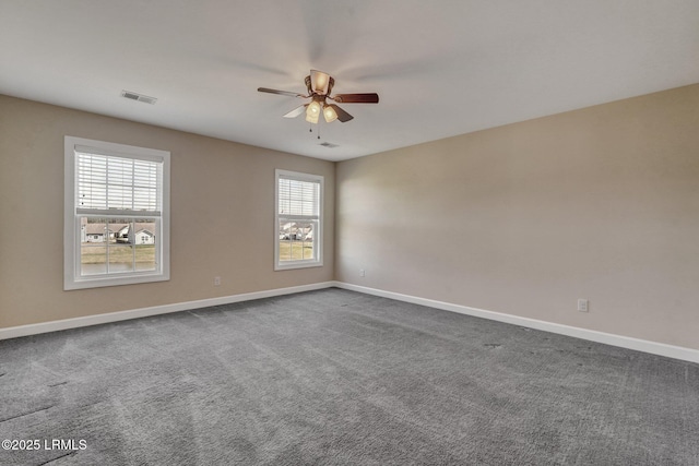 spare room featuring a ceiling fan, visible vents, dark carpet, and baseboards