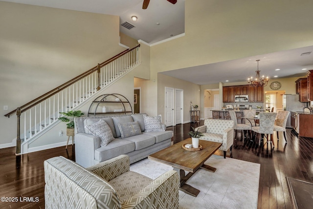 living area with visible vents, baseboards, dark wood-style floors, and stairs