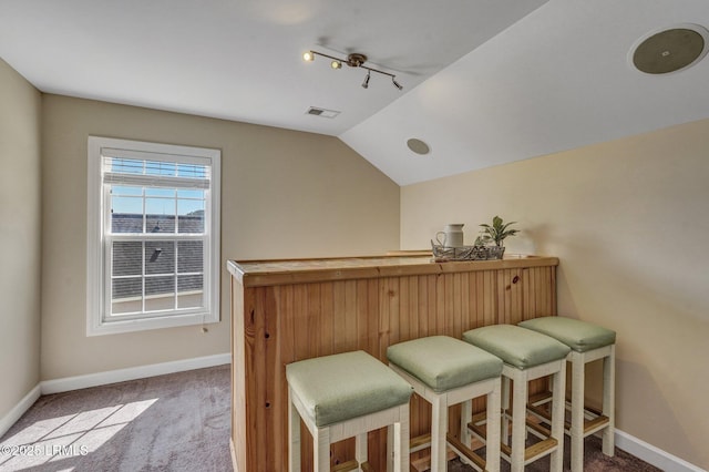 bar with visible vents, baseboards, a dry bar, lofted ceiling, and carpet floors