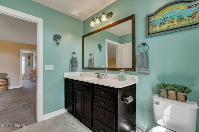 bathroom featuring baseboards, toilet, vanity, and tile patterned flooring