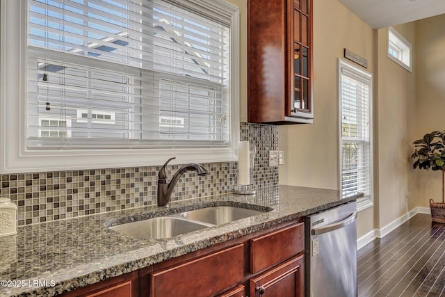 kitchen with a sink, glass insert cabinets, stainless steel dishwasher, decorative backsplash, and dark brown cabinets