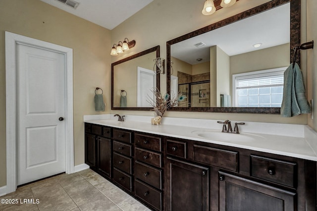 full bathroom with a sink, a shower stall, tile patterned floors, and double vanity