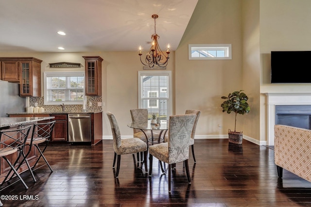 dining room featuring dark wood-type flooring, a notable chandelier, recessed lighting, and baseboards