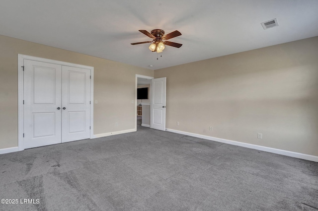 unfurnished bedroom featuring carpet, baseboards, visible vents, a ceiling fan, and a closet