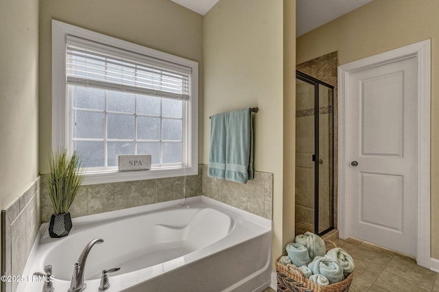 full bath featuring a stall shower, a bath, and tile patterned flooring