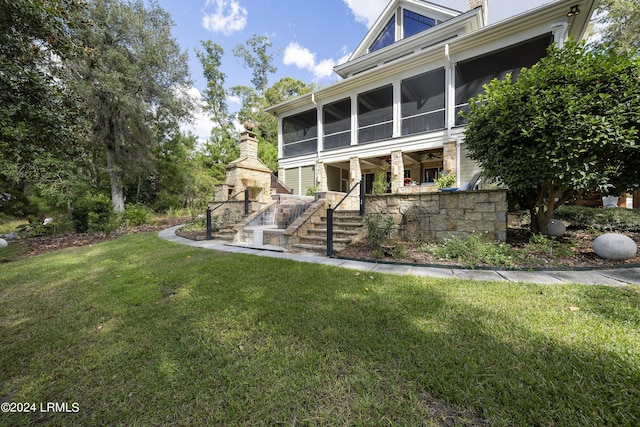 back of house featuring a lawn and a sunroom