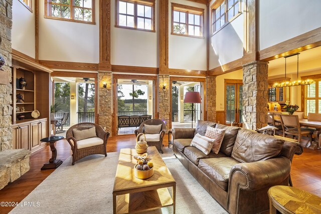 sunroom / solarium with a chandelier, a wealth of natural light, and decorative columns