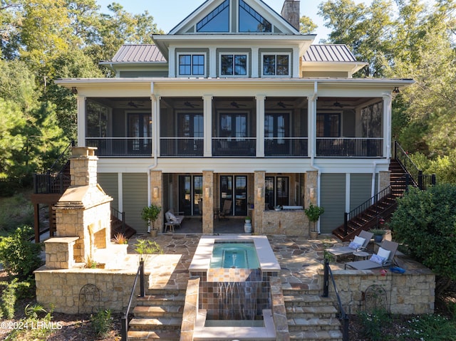 rear view of property with a patio area, stairway, metal roof, and a sunroom