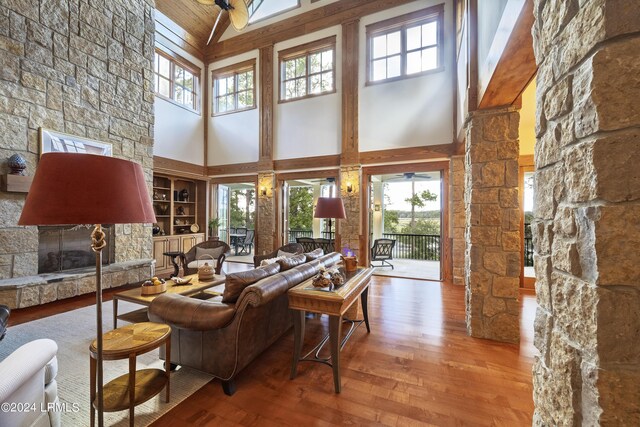 living room featuring a fireplace, wood finished floors, and ornate columns