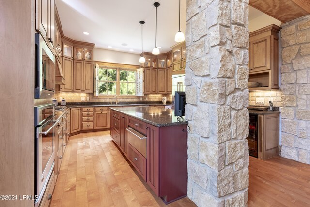 kitchen with oven, a sink, light wood-style floors, decorative backsplash, and a warming drawer