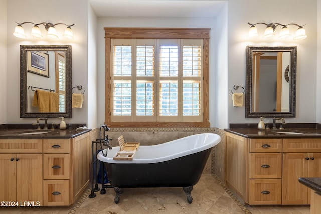 bathroom with a soaking tub, two vanities, and a sink