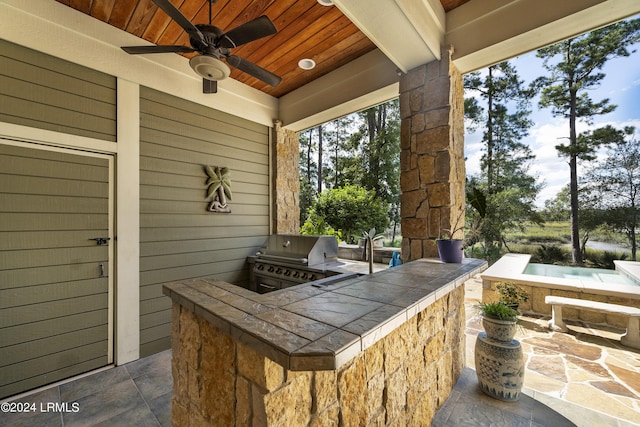 view of patio / terrace featuring a ceiling fan, exterior kitchen, and area for grilling