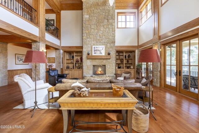 living room with french doors, wainscoting, a fireplace, and wood finished floors