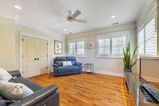 living room featuring ornamental molding, visible vents, and a healthy amount of sunlight