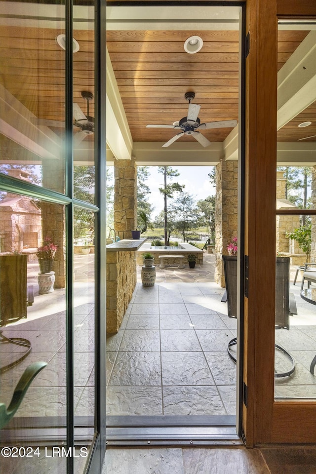 doorway featuring wood ceiling, ceiling fan, and a wealth of natural light