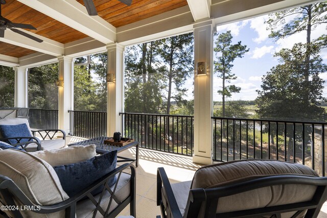 sunroom / solarium featuring wood ceiling, ceiling fan, and beam ceiling