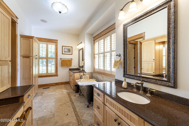 bathroom with two vanities, a sink, and baseboards