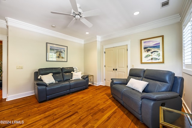 living area with hardwood / wood-style flooring, baseboards, visible vents, and crown molding