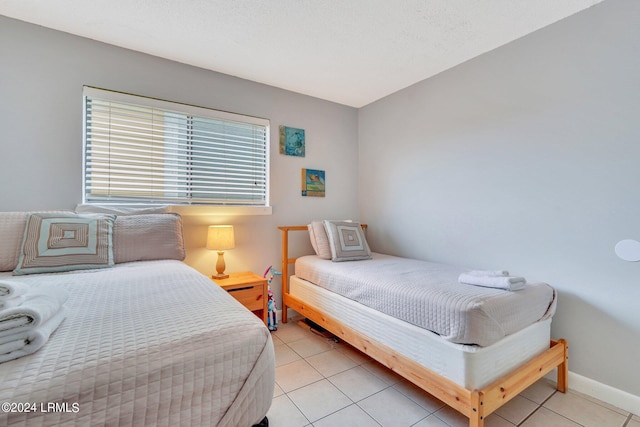 bedroom with light tile patterned floors and a textured ceiling