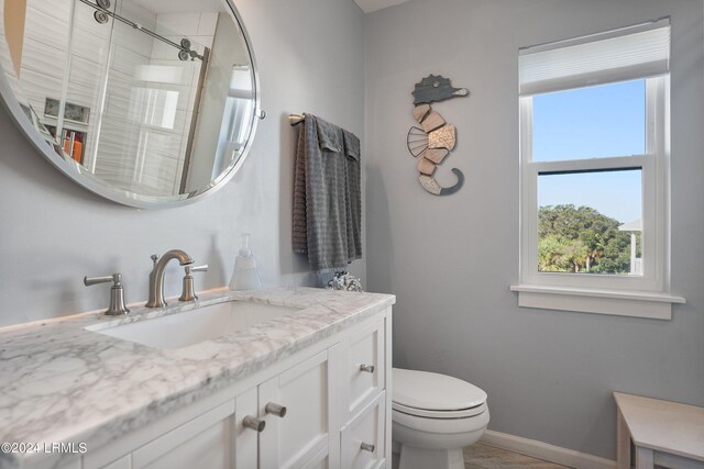bathroom featuring walk in shower, vanity, and toilet