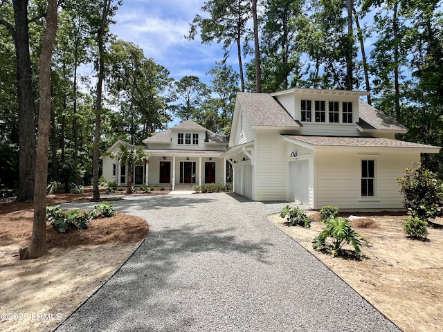14 Heron Pt, Okatie, SC 29909 - view of front facade featuring covered porch, roof with shingles, gravel driveway, and a garage