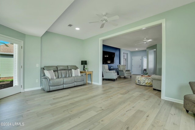 living room with ceiling fan and light hardwood / wood-style flooring