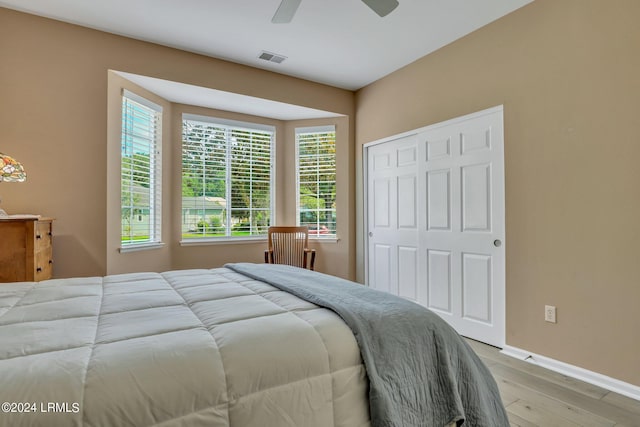 bedroom featuring light hardwood / wood-style flooring, a closet, and ceiling fan