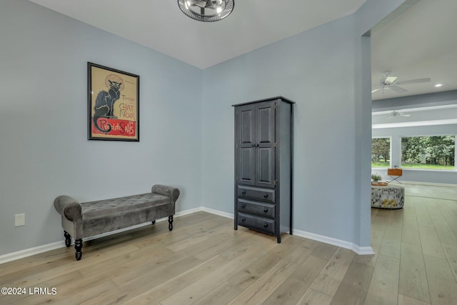 living area featuring light hardwood / wood-style floors and ceiling fan