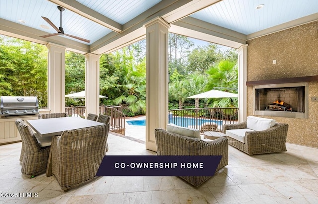 view of patio with grilling area, a fireplace, ceiling fan, and exterior kitchen