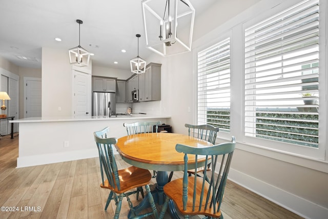 dining area with an inviting chandelier and light hardwood / wood-style flooring