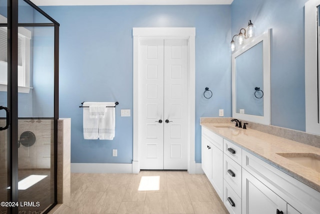 bathroom with tile patterned floors, vanity, and a shower with door