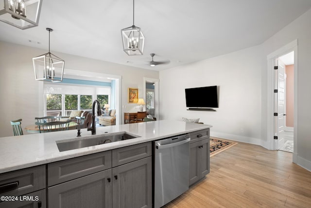 kitchen with sink, decorative light fixtures, light wood-type flooring, stainless steel dishwasher, and gray cabinets