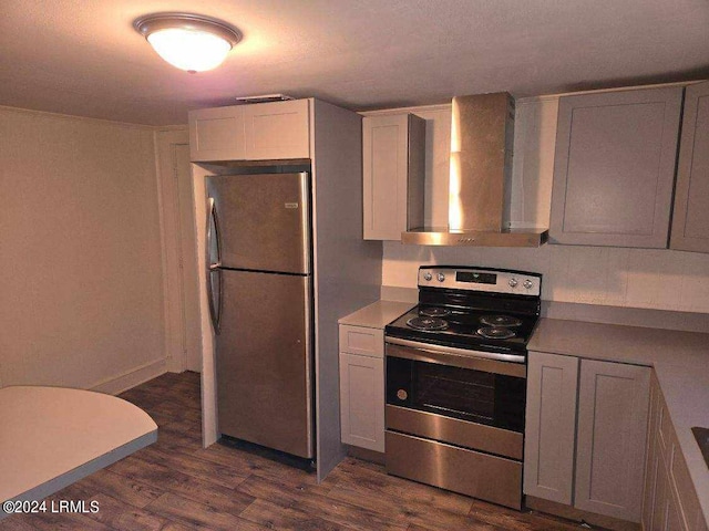 kitchen with dark hardwood / wood-style flooring, wall chimney range hood, stainless steel appliances, and white cabinets