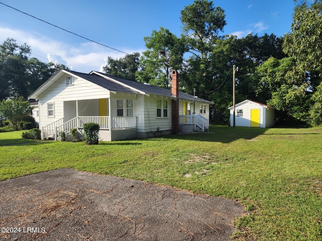 view of front of house featuring a shed, a front yard, and a porch