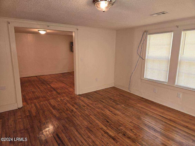 unfurnished room featuring dark hardwood / wood-style flooring and a textured ceiling