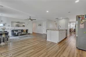 kitchen featuring sink, white cabinetry, stainless steel refrigerator, ceiling fan, and light hardwood / wood-style floors