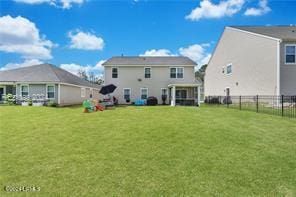 rear view of house featuring a yard